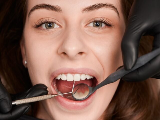 Diş eti çekilmesi muayenesinde periodontal sonda ile ölçüm yapan diş hekimi