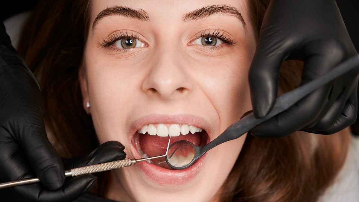 Diş eti çekilmesi muayenesinde periodontal sonda ile ölçüm yapan diş hekimi